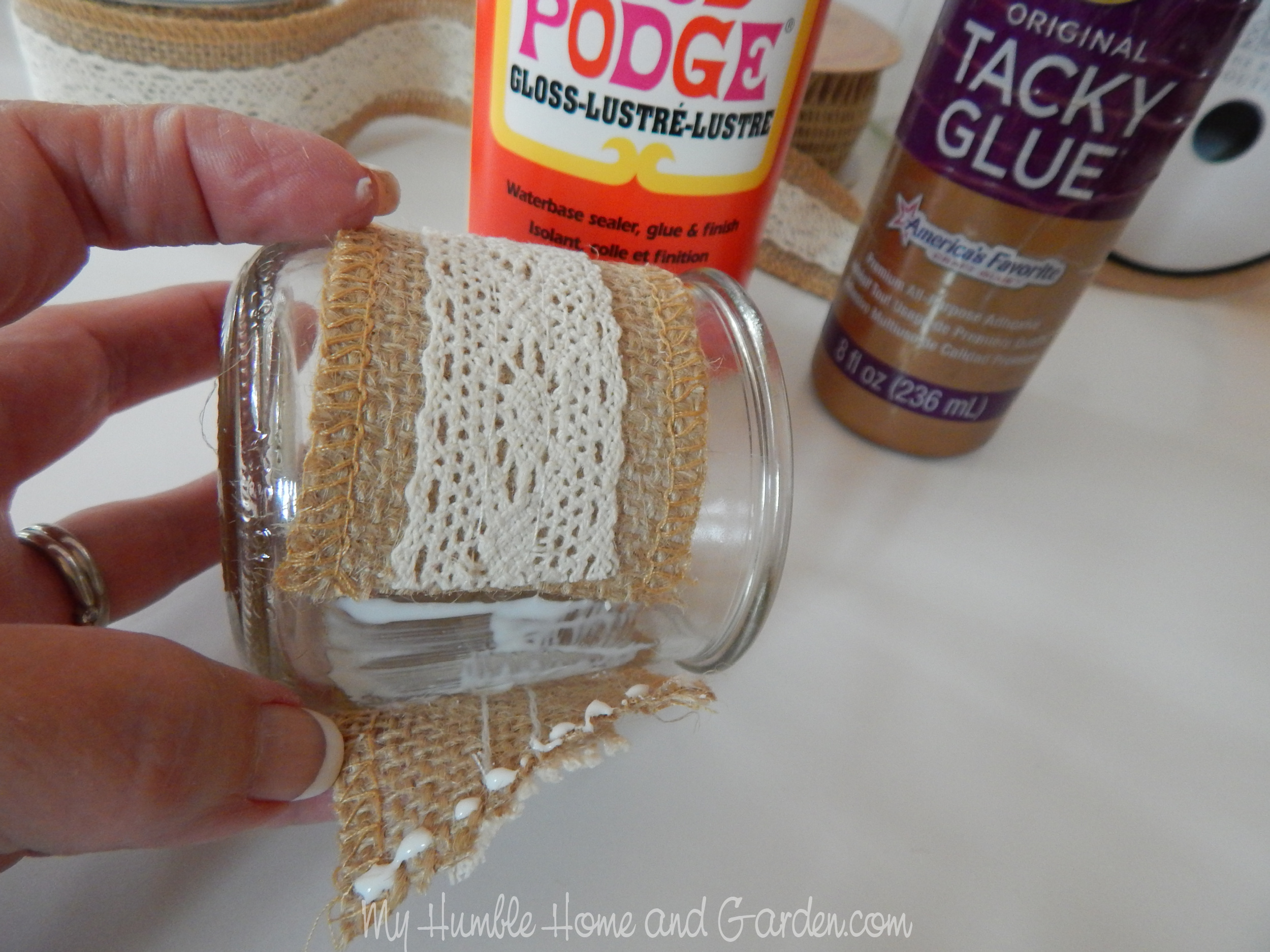 https://myhumblehomeandgarden.com/2021/07/12/shabby-chic-burlap-trim-yogurt-jars-easy-diy/add-tacky-glue-along-ends-2/